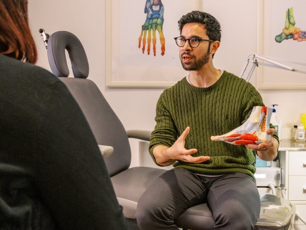 A podiatrist explaining foot anatomy to a patient
